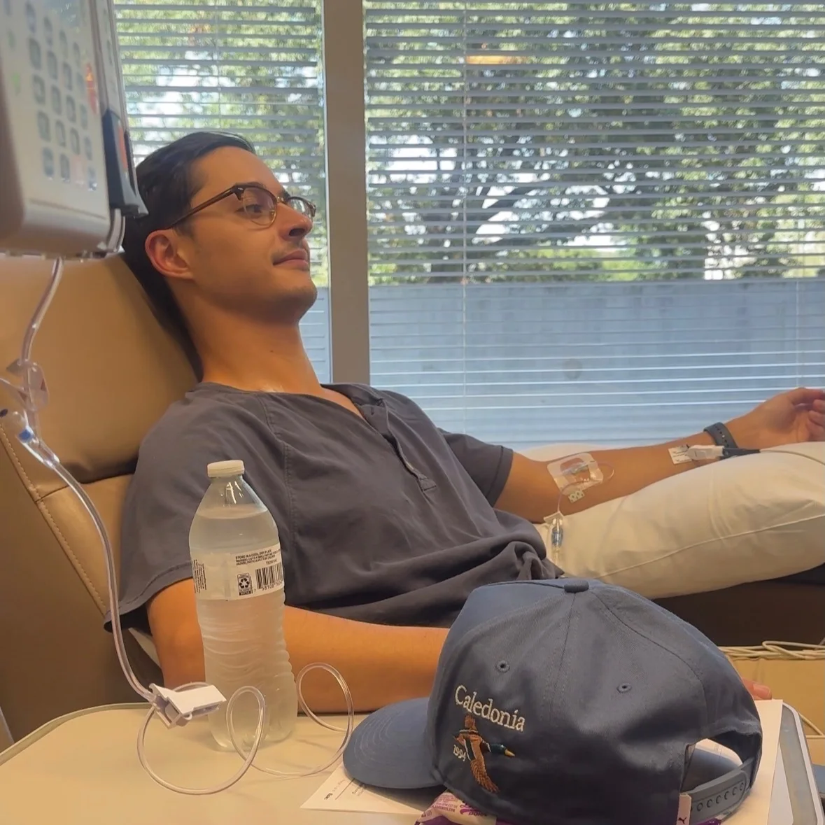 Tyler sitting in a treatment chair with a water bottle in front of him